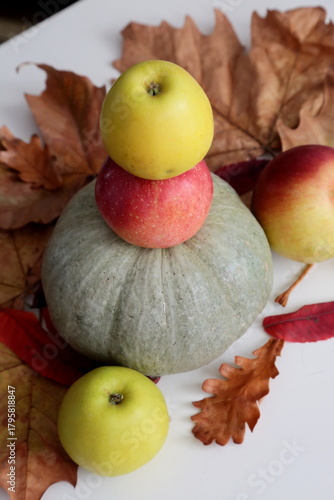 Pumpkin and apples laying  on the table