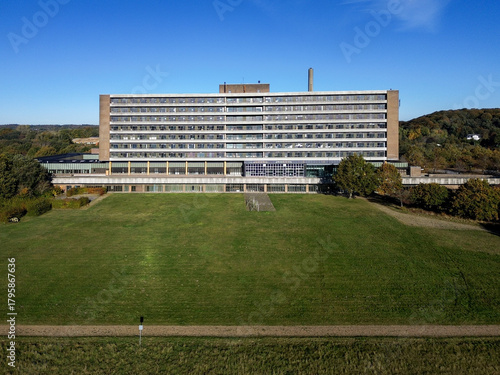 Aerial video of abandoned hospital surrounded by nature and autumn colors. Derelict building in rural landscape