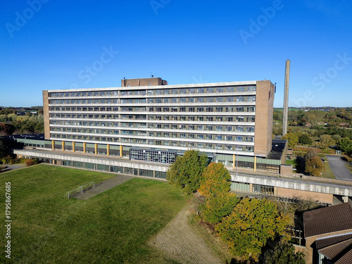 Aerial video of abandoned hospital surrounded by nature and autumn colors. Derelict building in rural landscape