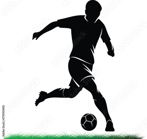 Silhouette of soccer player kicking a ball on grass