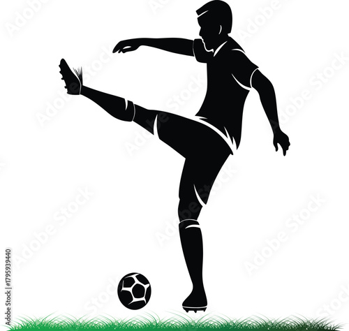 Silhouette of soccer player kicking a ball with grass