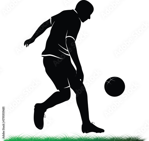 Silhouette of soccer player kicking ball on grass field