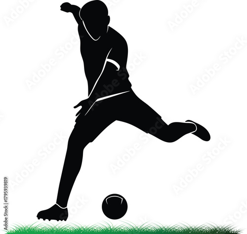 Silhouette of soccer player kicking ball on green field