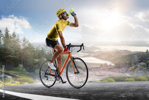Cycling. A captivating shot of a helmeted biker riding along an asphalt road, demonstrating the freedom and excitement of road riding. Cycling competitions. Active recreation. Sport.