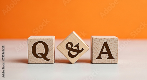 Wooden blocks spelling q & a on a table against an orange background representing questions answers and information resources online now