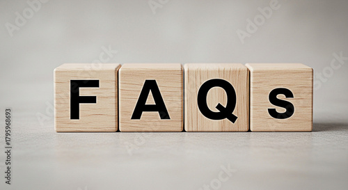 Wooden blocks spelling out faqs frequently asked questions concept for information help support assistance and customer service online