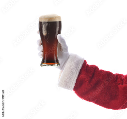 Santa Claus hand and arm holiding a glass of dark beer.