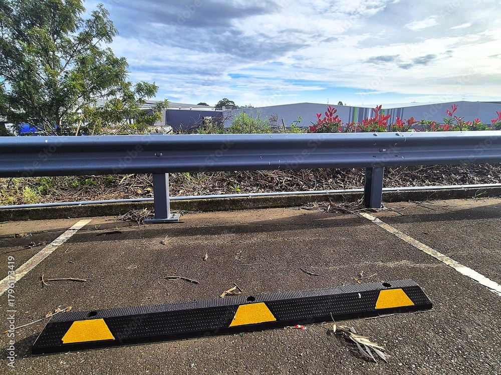 Ταπετσαρία Close-up of a steel guard rail at the edge of a parking lot with warehouses in the background