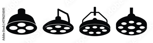Set of surgical operating room ceiling mounted examination lights with multiple bulbs visible