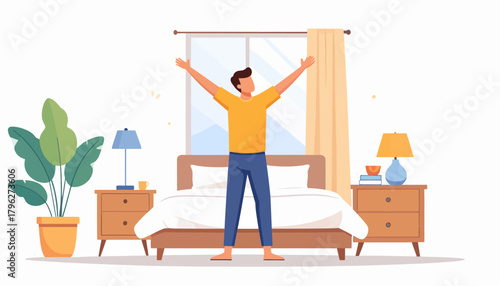 Cheerful man in pajamas stretches his arms after waking up, standing in a bright and modern bedroom with a large window