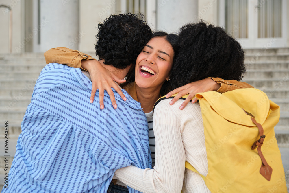 Obraz premium Happy students embracing, sharing a group hug, and smiling on university campus steps