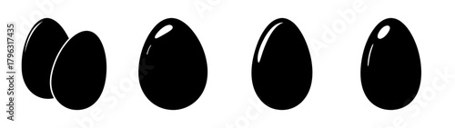 Four shiny black eggs arranged in a row one cluster two singles