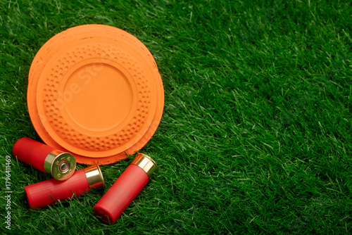 Clay disc flying targets and shotgun bullets on green grass background ,Clay Pigeon target