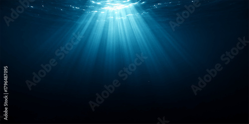 Bright blue ocean sunlight bursts with rays through the dark underwater scene