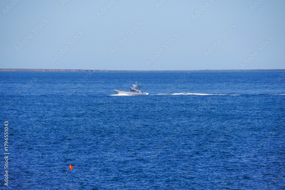 Obraz premium 納沙布岬と歯舞諸島の間を行く漁船