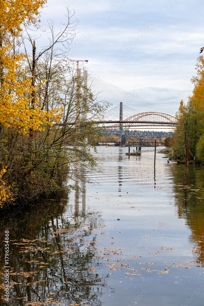 Fototapeta premium Autumn River Scene With Bridge Construction in New Westminster, Greater Vancouver