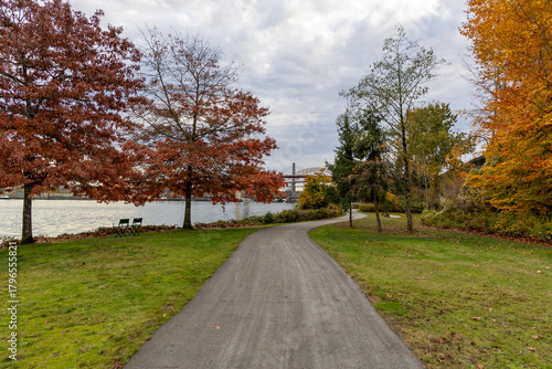 Autumn Riverside Path in New Westminster Park With Colorful Trees and Calm Water View