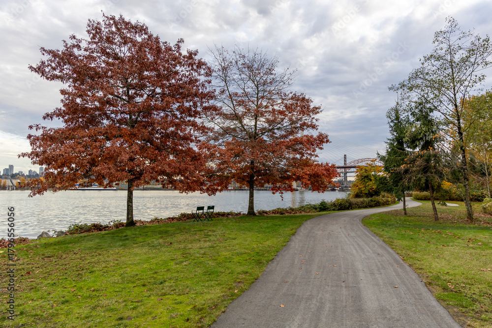 Obraz premium Autumn Riverside Park Path With Red Leaves Near New Westminster, Vancouver, BC