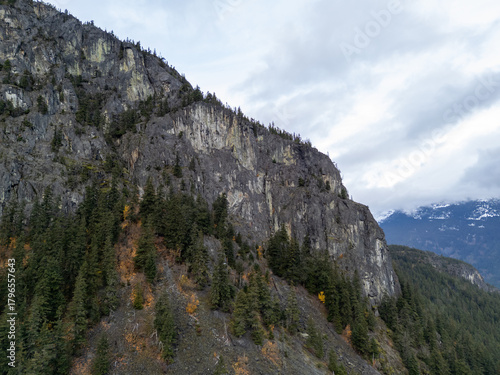 Photography Dramatic Rocky Mountain Cliff With Forested Slopes Above Snow-Capped Peaks in BC