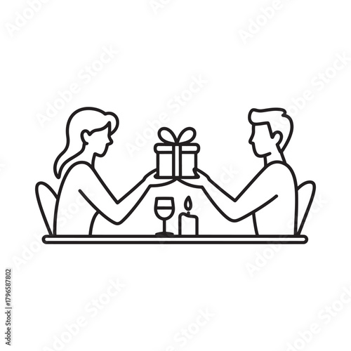 Couple exchanging a gift during a romantic candlelit dinner