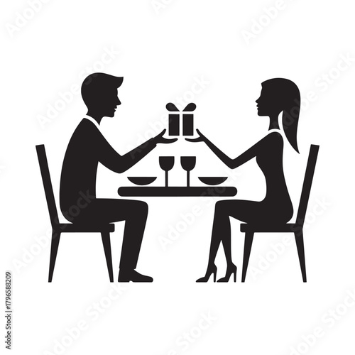 Couple exchanges gift during romantic dinner silhouette