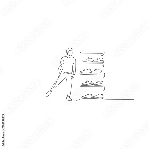 Man standing next to a shoe rack full of shoes