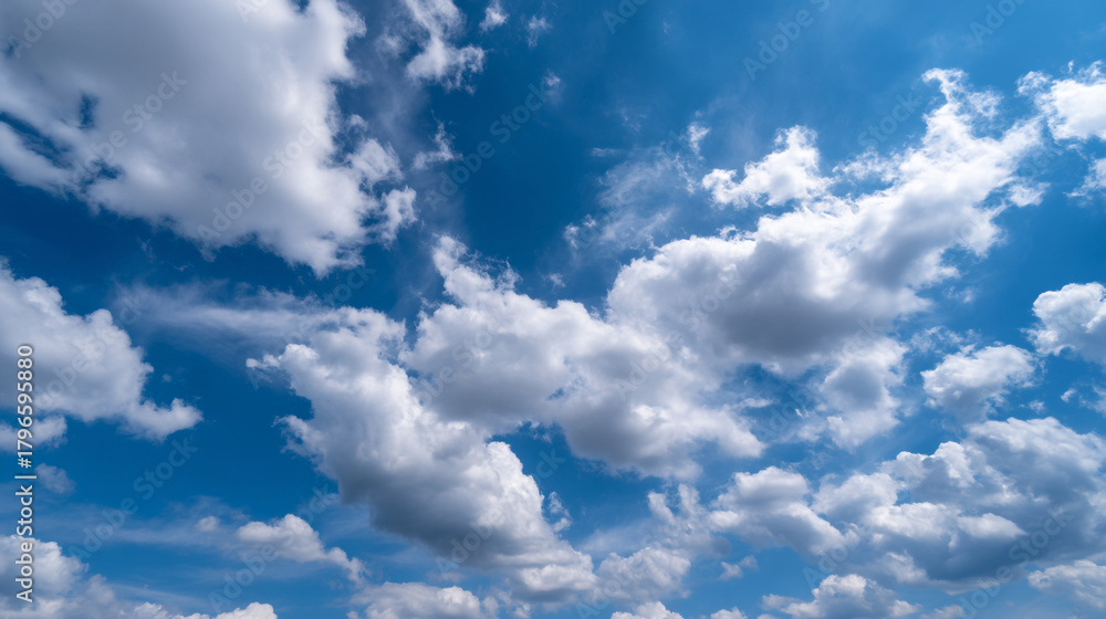 Naklejka premium A view of a bright blue sky filled with many fluffy white cumulus clouds on a sunny day
