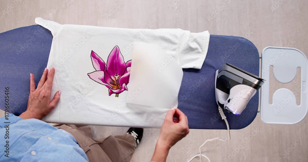 Obraz premium Woman Customizing T-shirt Design With Iron Transfer Press