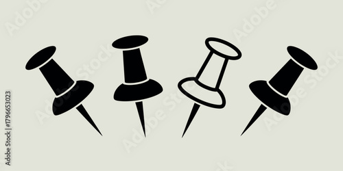 Four black thumbtacks pushed into a light background