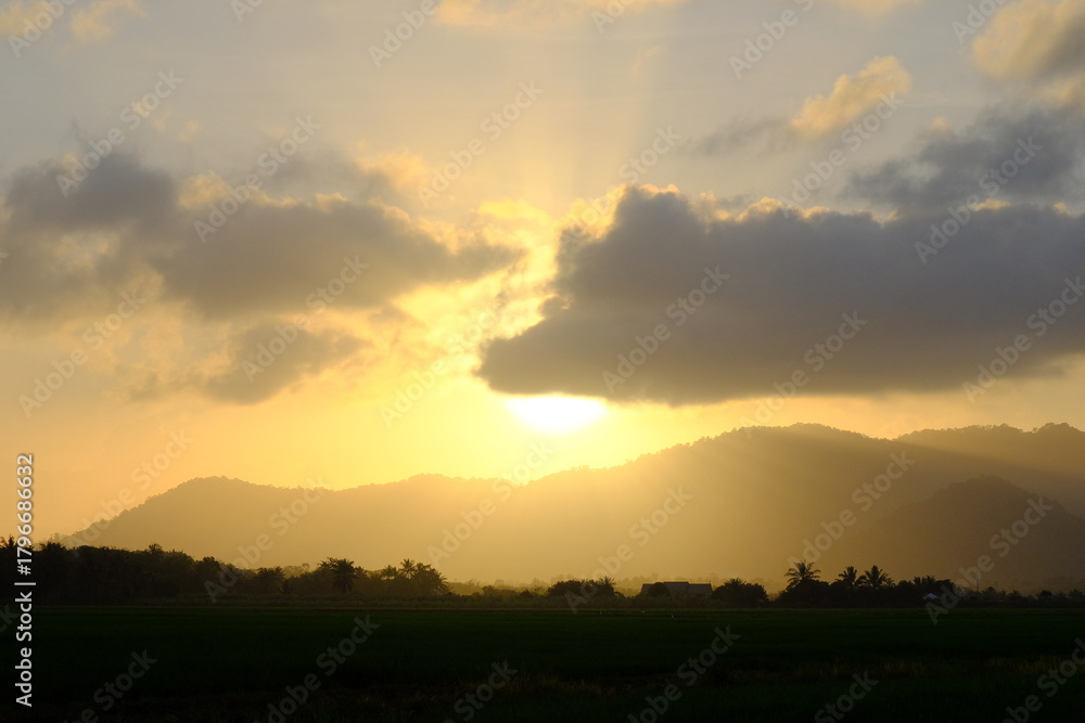 Obraz premium Dramatic Sunshine Burst over Hills and Paddy Field
