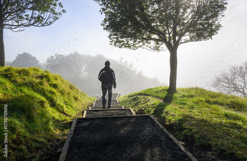 A tourist walking at Mt Eden summit in the fog. Auckland.