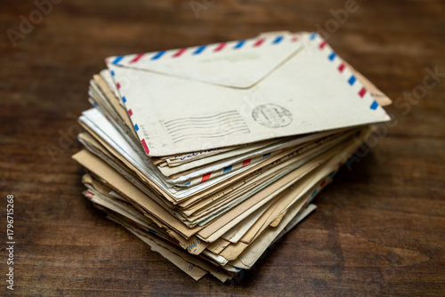 Old letters in envelopes on a wooden table.Memories on paper.A stack of postal envelopes.