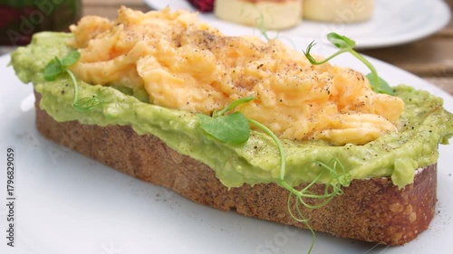 Avocado toast with creamy scrambled eggs - breakfast close-up