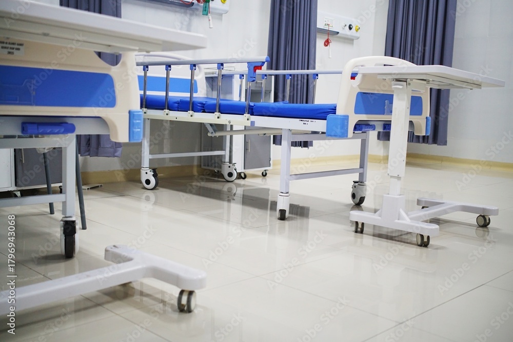 Fototapeta premium Clean and empty hospital ward with modern medical beds and equipment, ready for patient care.
