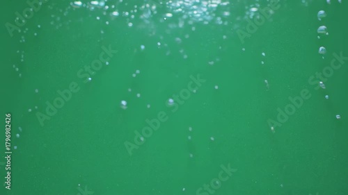 A Beautiful Display of Floating Bubbles in Clear Turquoise Water, Capturing the Mystery and Beauty of Underwater Life with Iridescent Reflections. Green screen video.