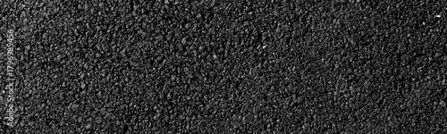close-up texture of smooth, freshly laid asphalt surface with fine granules and a uniform appearance, neutral background, clear negative space, clean composition, balanced framing, minimalist layout