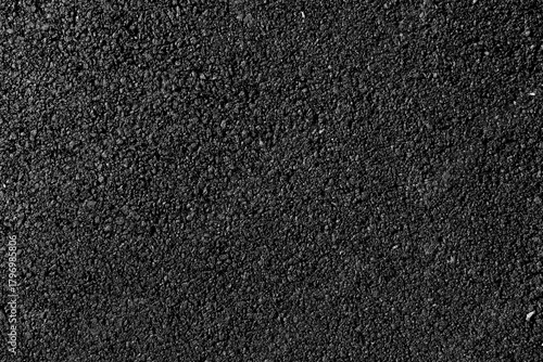close-up texture of smooth, freshly laid asphalt surface showcasing fine granules and a uniform appearance, neutral background, clear negative space, clean composition, balanced framing, minimalist