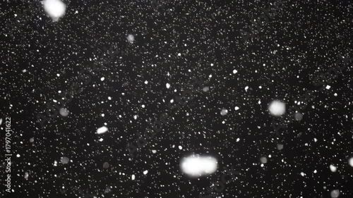 black background snow particles falling night, cinematic monochrome closeup of soft bokeh flakes drifting through cold air, slow