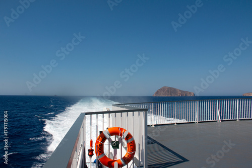 Orange Lifebuoy with rope on the quay in the old port on the Sea, blue sky, copy space