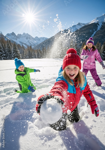 Happy children having a fun snowball fight in a snowy mountain landscape. Vertical photo of kids playing outdoors on a sunny winter vacation
