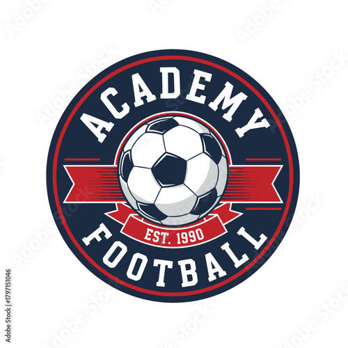A circular emblem showcasing a soccer ball, red ribbon and text. Colors are navy, white, and red