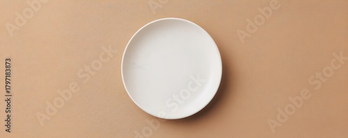A single white ceramic oval plate resting on a textured tan surface dish