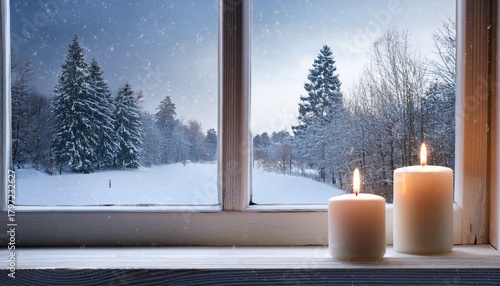 two candles on a windowsill snowy scene