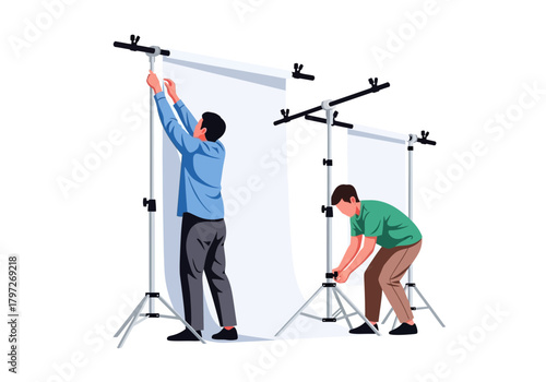 Two men setting up white photography backdrops with stands and clamps.