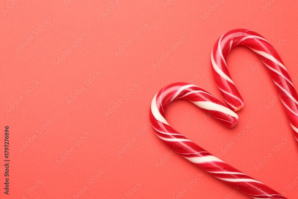 Fototapeta premium Heart made of tasty candy canes on red background, flat lay with space for text. Merry Christmas and Happy New Year