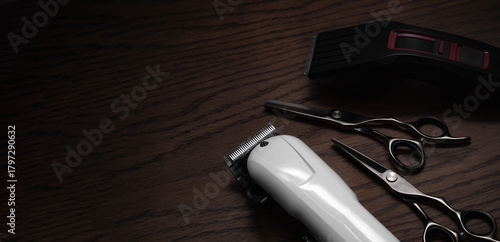 Hairdressing and barber tools. Professional scissors and hairdressing clippers. Dark wooden background.