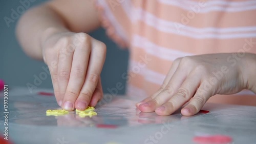 A girl makes a toy out of plastic. Creative, technology, leisure and education concept. Slow Motion Effect.