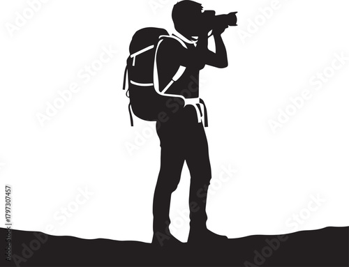 Silhouette of a photographer with backpack on a landscape taking a photo