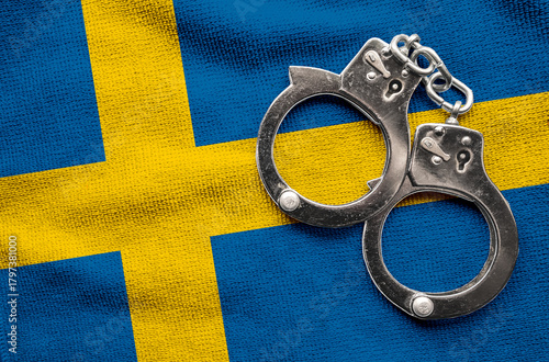 Flag of Sweden and police handcuffs. Crime and offenses in country Concept
