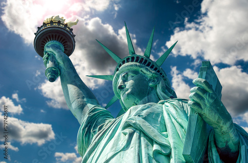 Eingescanntes Diapositiv einer historischen Farbaufnahme der Freiheitsstatue in New York in extremer Unteransicht bei sonnigem Wetter und aufgelockerter Bewölkung